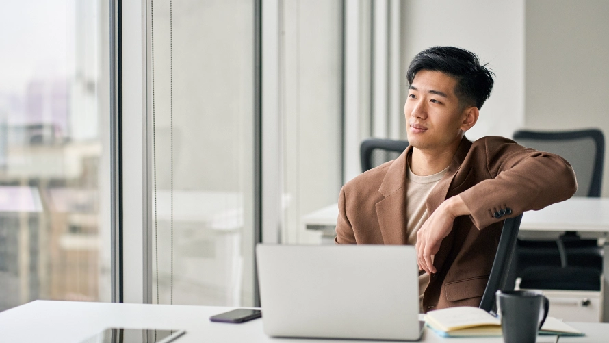 man behind desk with laptop