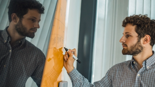 Atradius Colleague working on a board in the Paris Office