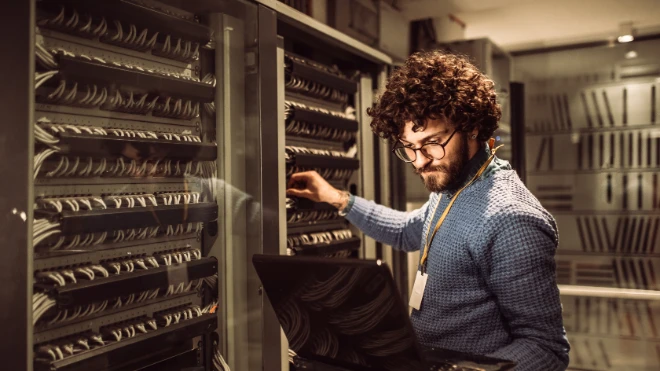 bearded male worker in mainframe room