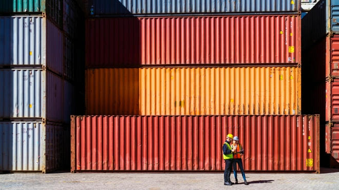 Two workers having a conversation about containers