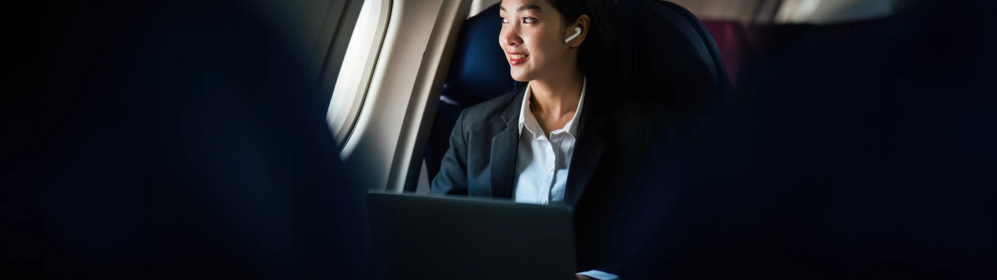 Successful Asian business woman working in airplane cabin during flight